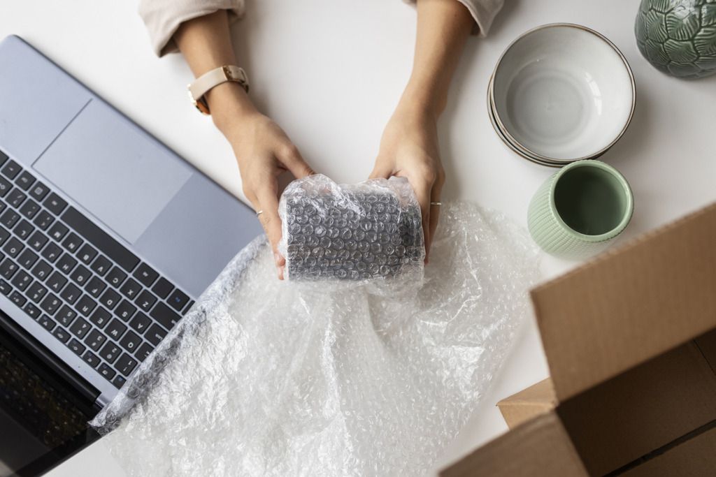 Emballage d'un objet fragile avec du papier bulle pour expédition et protection industrielle