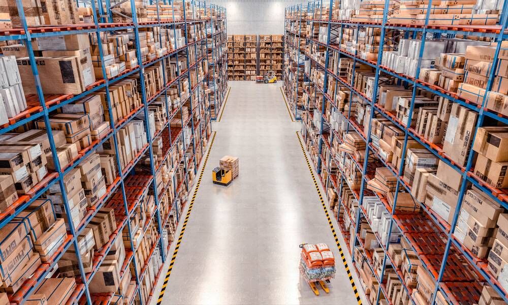 Allée centrale d'un entrepôt avec rayonnages de cartons pour le stockage et la logistique industrielle