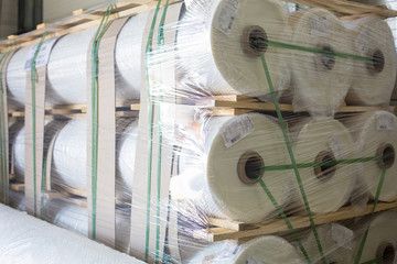 Rouleaux de film plastique palettisés et cerclés pour le stockage et la logistique industrielle.