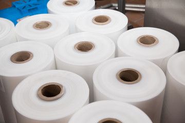 Rouleaux de film plastique blanc pour l'emballage industriel et la protection des produits.