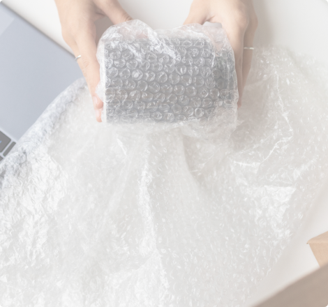 Emballage d'un objet fragile avec du film à bulles pour protection durant le transport.