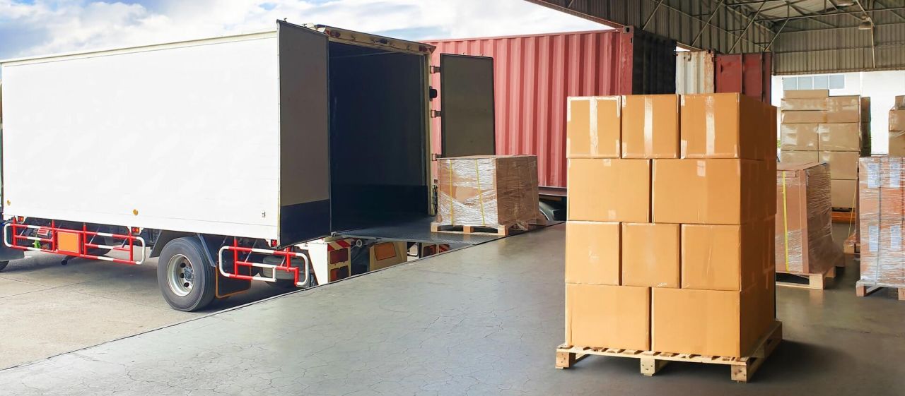 Chargement de cartons sur palettes dans un camion pour la distribution logistique.