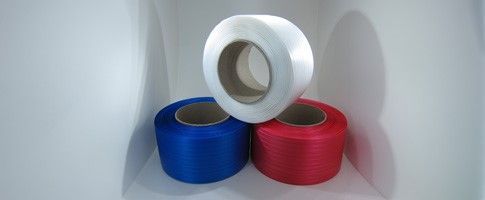 Rouleaux de cerclage en plastique rouge, bleu et blanc pour sécuriser les emballages industriels.