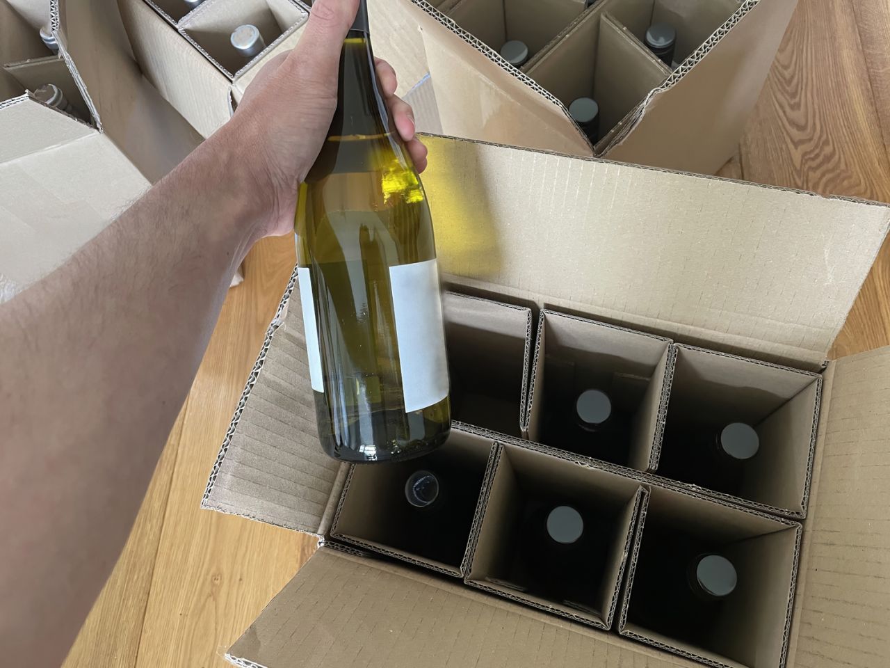 Bouteilles de vin emballées dans des cartons pour transport et stockage sécurisé.