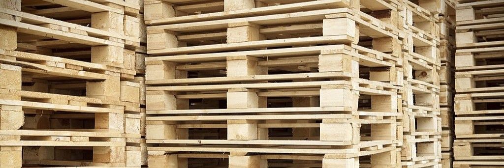 Palettes en bois empilées pour le stockage et l'expédition de marchandises industrielles.