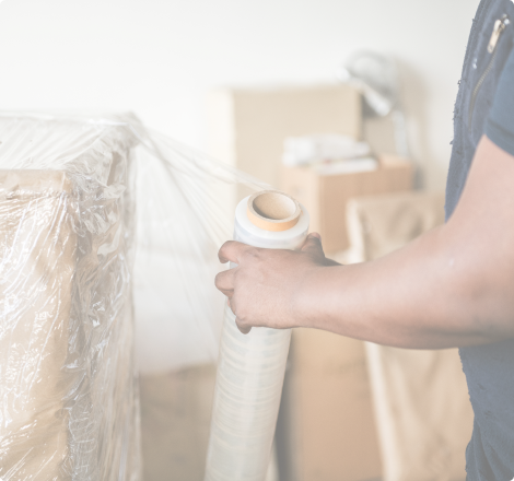 Personne enveloppant des cartons avec du film plastique pour l'emballage industriel.