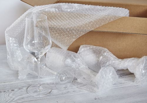 Emballage de verres à vin dans du papier bulle pour un transport sécurisé et sans casse